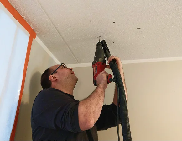 A person drilling the roof top of the room